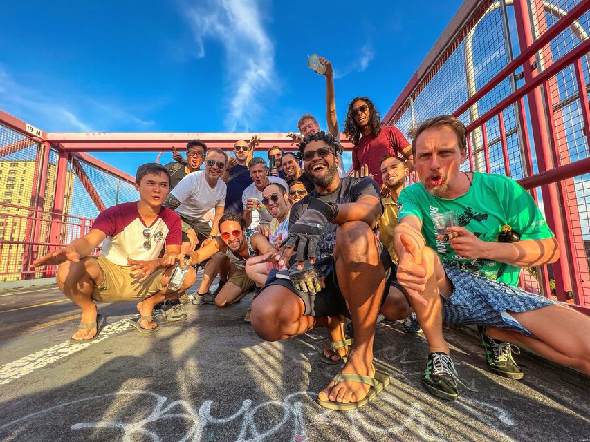 Summit crew gathered on a bridge, laughing in the sun